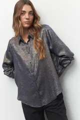 Camisa de manga larga de tela brillante y texturizada, con botones a tono y diseño versátil.