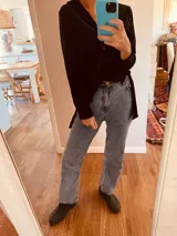 Camisa larga de terciopelo negro con botones al frente, tajos a los costados y espalda más larga que el frente.