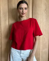 Remera negra con cuello redondo y mangas cortas, con detalle de pespuntes blancos en cuello, mangas, bolsillos frontales y ruedo.