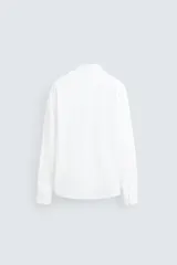 Camisa celeste a rayas verticales blancas, de corte recto, con cuello italiano abierto, manga larga con puños abotonados y cierre frontal con botones.