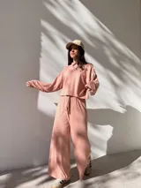 Conjunto deportivo color rosa compuesto por un buzo de cuello alto y mangas largas, y un pantalón palazzo con cintura elastizada y cordón ajustable.