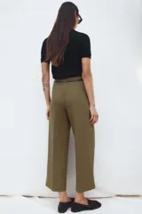 Pantalón culotte color verde oliva, de tiro medio y pierna ancha. Incluye cinturón ajustable con hebilla metálica y cierre lateral con cremallera oculta.