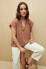 Blusa color ladrillo con escote en V y mangas cortas.