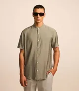 Camisa de hombre color verde oliva, corte slim, confeccionada en tejido viscolino con textura. Tiene cuello padre, mangas cortas y abotonadura frontal.