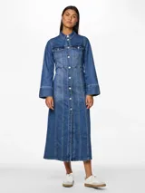 Vestido largo camisero de denim azul con cuello clásico, cierre frontal con botones, mangas largas con puños abotonados, bolsillos en el pecho y corte evasé.