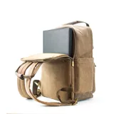 Mochila marrón de tela canvas con compartimento para notebook y accesorios de mate.