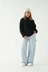 Sweater negro de punto grueso con diseño de trenzas.