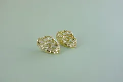 Par de aros colgantes con forma orgánica irregular, con perforaciones y textura rugosa.