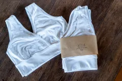 Pack de dos tops blancos de lycra de algodón, con calce al cuerpo, bordes ribeteados y escote cruzado para facilitar la lactancia.