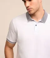 Polo de manga corta color beige, confeccionada en algodón con cuello jacquard y ribete en las mangas.