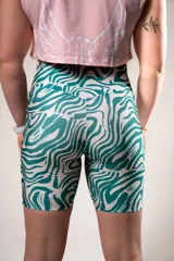 Calza biker deportiva con estampado abstracto en tonos verde y blanco.