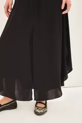 Falda midi negra con tajo lateral, breteles finos y escote en V con encaje.