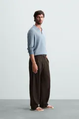 Polo celeste de punto con mezcla de algodón, seda y lino. Corte relaxed fit, cuello solapa con abertura frontal, manga larga y acabados en rib.