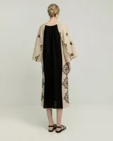Túnica larga de lino color beige con bordados negros en mangas y ruedo.