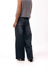Jean wide leg de tiro medio en color azul oscuro con costuras verticales visibles que aportan estructura. Presenta un corte amplio y relajado con diseño de cinco bolsillos.