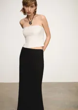 Top sin mangas, color blanco, con diseño ajustado y detalles de pliegues al frente.
