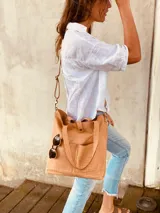 Cartera tipo tote bag color beige con textura símil cocodrilo, doble asa corta y correa larga extraíble y ajustable. Tiene dos bolsillos externos grandes y cierre superior con botón a presión.