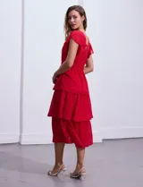 Vestido blanco de gasa con capas de la marca Julia Jordan. Tiene escote en V, mangas cortas con volados, corte en la cintura, abertura central en la espalda con cierre invisible y forro interno a tono.