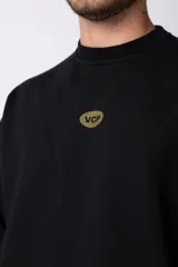 Buzo color beige de frisa con cuello redondo, mangas largas y logo bordado en el pecho.