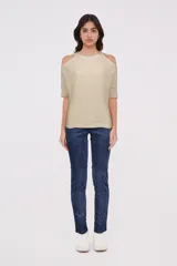 Sweater color crema de tejido de punto, con cuello redondo y hombros descubiertos.