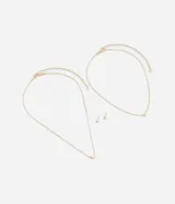 Conjunto de collar de doble cadena dorada, uno con dije de corazón y otro con dije de cristal cuadrado, y aros tipo botón con cristal cuadrado.