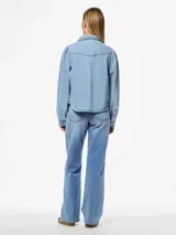 Camisa de denim celeste de algodón, de corte regular, con cuello clásico, mangas largas con puños abotonados, bolsillos con solapa abotonada en el pecho y cierre frontal con botones.