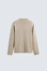 Sweater color arena de punto con cuello redondo y manga larga. Tejido con mezcla de algodón y cashmere.