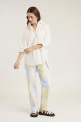 Camisa blanca de mangas largas con puños abotonados, cuello clásico y bolsillo en el pecho.