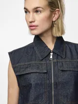 Chaleco de denim azul oscuro con cuello con solapas, cierre frontal con cremallera metálica y dos bolsillos de parche en el pecho.