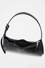 Bolso de hombro negro con asa ajustable mediante hebilla metálica. Tiene un bolsillo interior con cremallera y cierre principal también con cremallera.