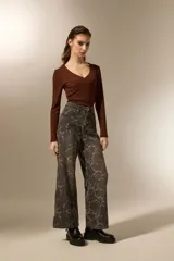 Pantalón de jean azul claro con estampado abstracto desgastado, corte baggy y tiro medio.