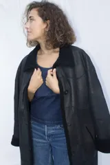 Abrigo gamulán negro de cuero genuino con cuello y puños de piel sintética.