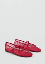 Zapato estilo bailarina color rojo, con diseño de rejilla, lazo decorativo y cierre de tira con hebilla.