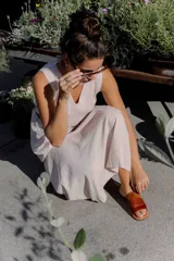 Sandalias de cuero negras con diseño de tiras cruzadas y detalle de elástico en el talón.