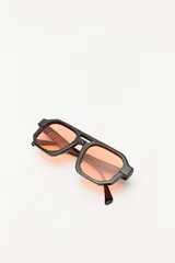 Lentes de sol con marco geométrico negro y cristales color naranja.