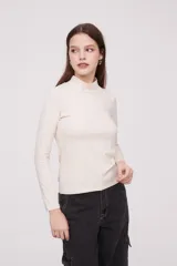 Polera negra de manga larga y cuello alto, ajustada al cuerpo y perfecta para layering.