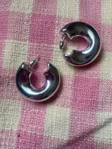 Aros metálicos plateados con forma irregular.