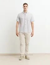 Camisa de manga corta a rayas verticales celestes y blancas, con cuello abotonado y corte clásico.