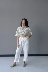 Top cruzado escotado de tusor de algodón con estampado de lunares verdes, cintura elastizada y manga corta holgada.