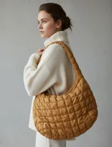 Bolso tipo hobo acolchado color mostaza, con costuras en patrón de rombos.