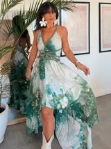 Vestido largo de tela fluida, color verde esmeralda con estampado abstracto en tonos turquesa y detalles dorados. Diseño asimétrico con un solo tirante tejido en el hombro.