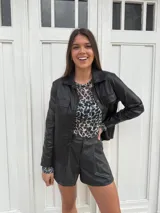 Chaqueta plateada metalizada con cuello camisero, cierre frontal con botones, bolsillos de parche en el pecho y corte recto.