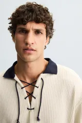 Sudadera color crema de tejido con estructura vertical, corte relaxed fit, cuello polo combinado en color azul marino y ajuste frontal con cordón.