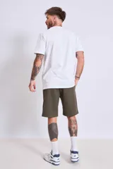 Remera azul marino de algodón con cuello redondo y manga corta. Presenta un pequeño bordado de un pájaro en el área del pecho.