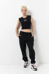 Babucha deportiva de algodón gris, con elástico en la cintura y puños ajustables, y dos bolsillos laterales.