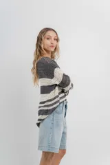Sweater tejido calado a rayas horizontales anchas en color gris oscuro y crudo, con escote en V y corte recto.
