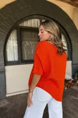 Blusa celeste de lino con cuello en V, mangas cortas con dobladillo y cierre lateral con botones de madera.
