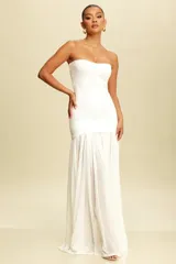 Vestido largo de fiesta blanco, estilo strapless, con corte ajustado en la parte superior y falda larga con caída fluida.