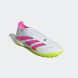 Championes de fútbol Adidas Predator League sin cordones, diseñados para canchas de pasto sintético. Presentan un exterior sintético con tecnología Hybridfeel para un mejor control de la pelota, diseño en color blanco con las tres tiras en fucsia y una suela de caucho estriada en color verde lima.