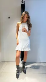 Vestido corto rojo de tela polina, con cuello halter, sin mangas y volado en el ruedo.